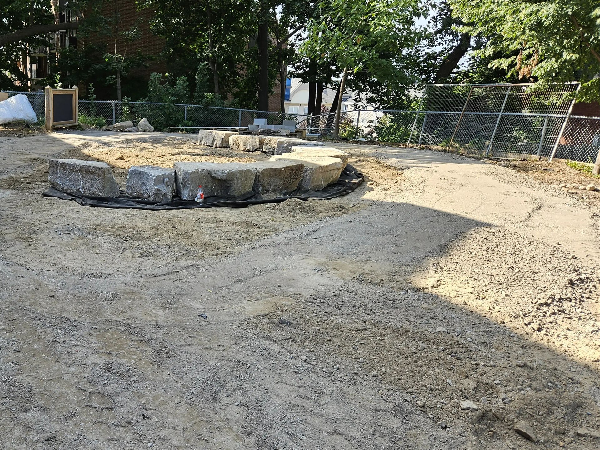 Large stone blocks arranged as curved landscape edging on a graded aggregate base.